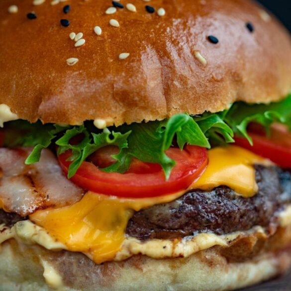 Hambúrguer caseiro alto e suculento com queijo derretido, feito com blend de carnes artesanal